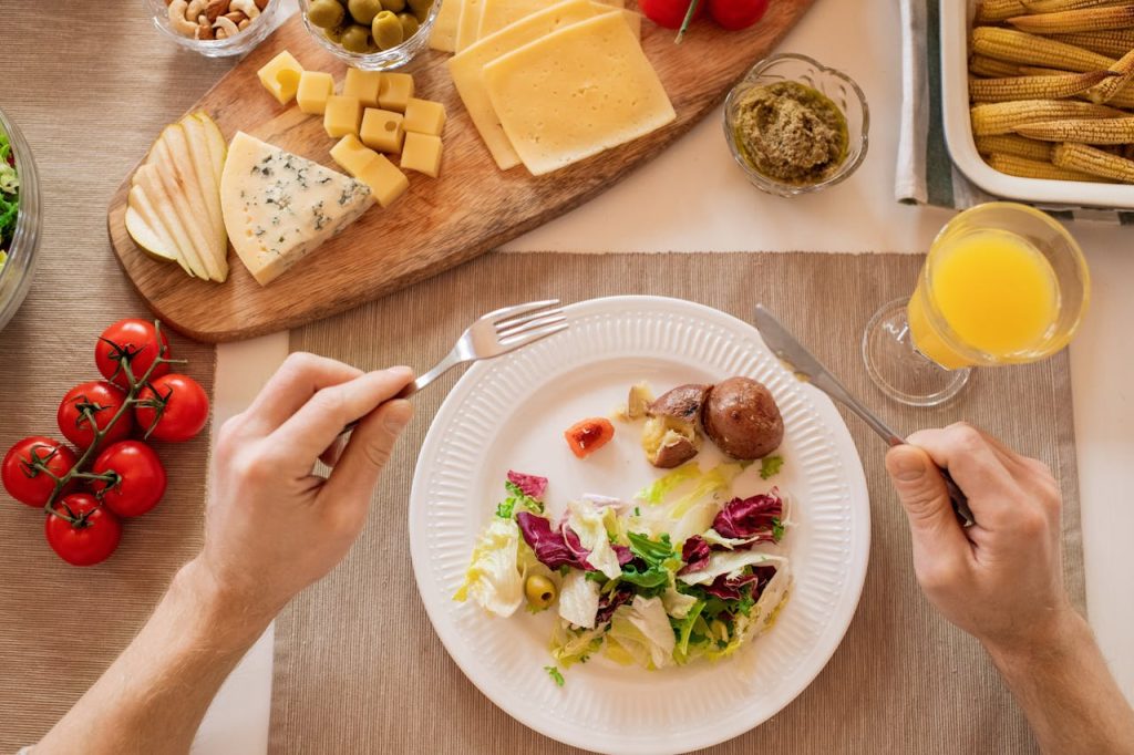 A vibrant lunch setting with salad, cheese, and orange juice, perfect for a healthy meal.